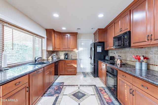 kitchen with light tile patterned flooring, sink, black appliances, dark stone counters, and decorative backsplash