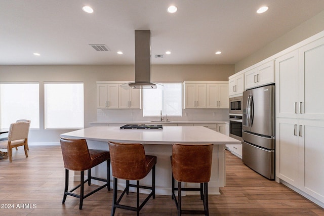 kitchen with a kitchen island, appliances with stainless steel finishes, and white cabinetry