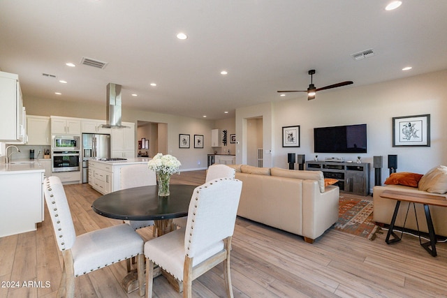 dining area featuring light hardwood / wood-style floors, sink, and ceiling fan