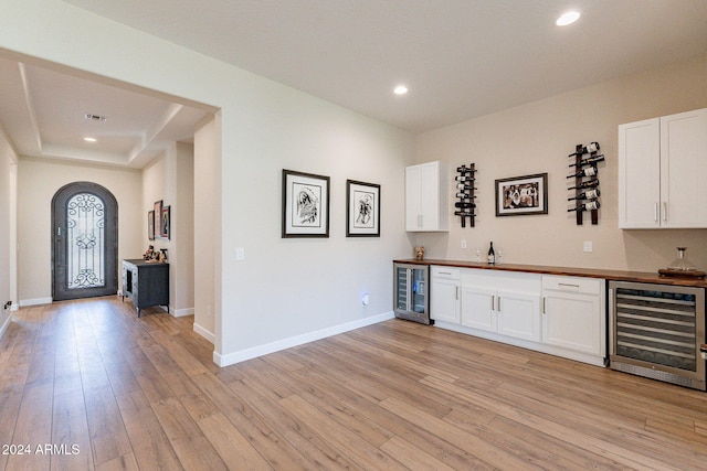 bar with white cabinetry, light hardwood / wood-style flooring, and beverage cooler