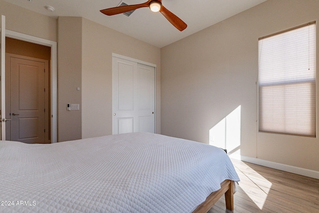 bedroom with light hardwood / wood-style floors, multiple windows, and ceiling fan