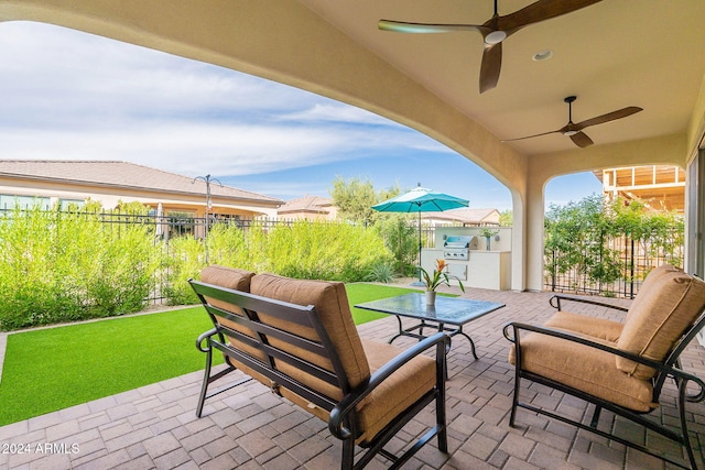 view of patio with area for grilling and ceiling fan