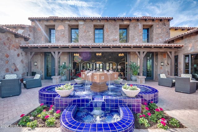 exterior space with outdoor lounge area and pool water feature