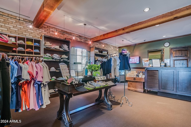 interior space featuring crown molding, beam ceiling, and brick wall