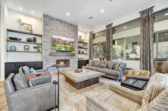 living room featuring a wealth of natural light, a fireplace, and light hardwood / wood-style floors