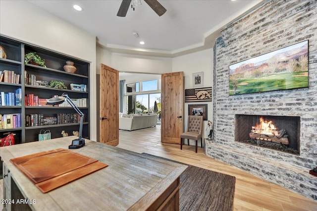 office space featuring wood-type flooring, a brick fireplace, and ceiling fan