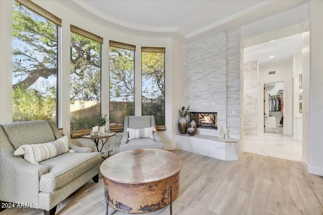 sitting room with a multi sided fireplace and light hardwood / wood-style floors