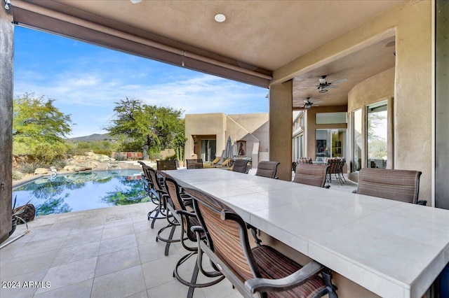 view of patio featuring ceiling fan and a bar