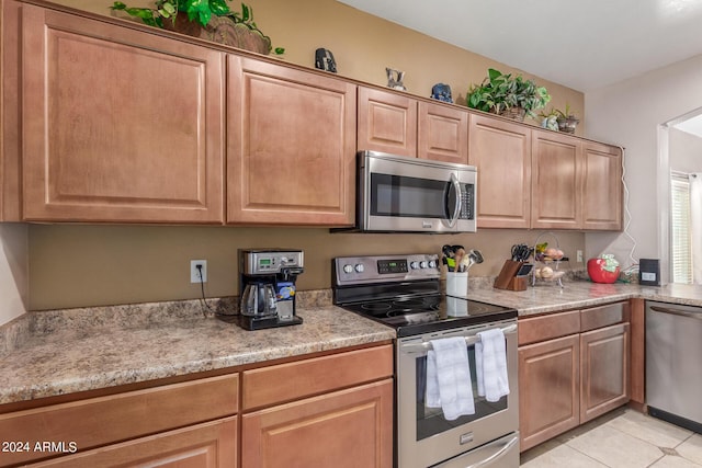 kitchen with light tile patterned flooring and appliances with stainless steel finishes