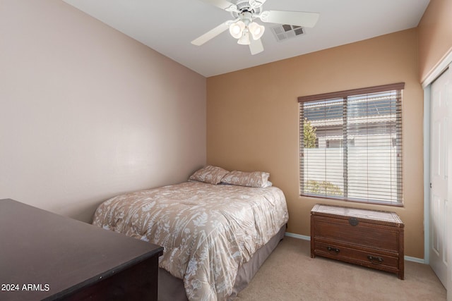 bedroom featuring light colored carpet, a closet, and ceiling fan