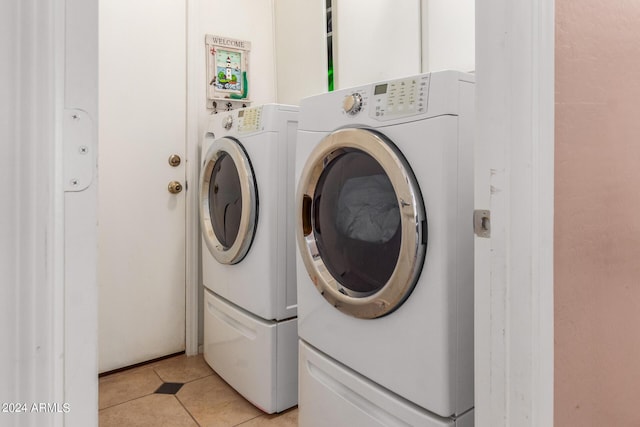 laundry room featuring light tile patterned floors and washer and clothes dryer