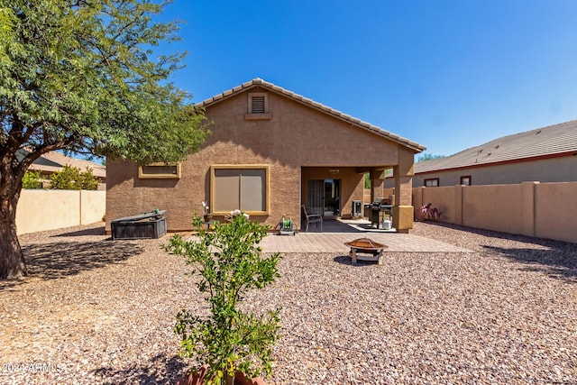 rear view of house featuring a patio and an outdoor fire pit