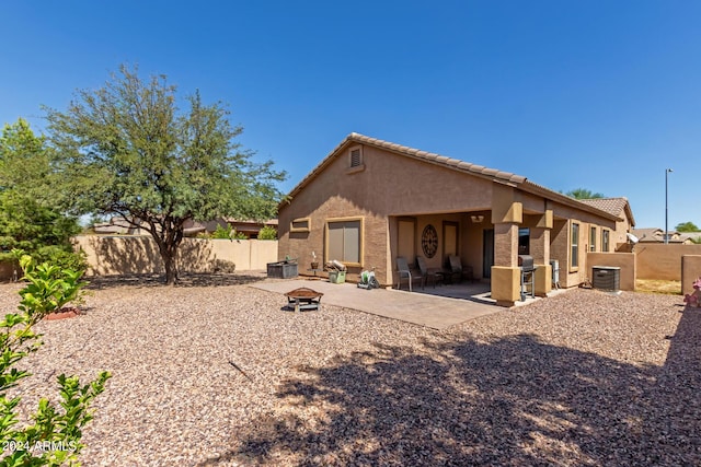 rear view of house with an outdoor fire pit, a patio area, and central air condition unit