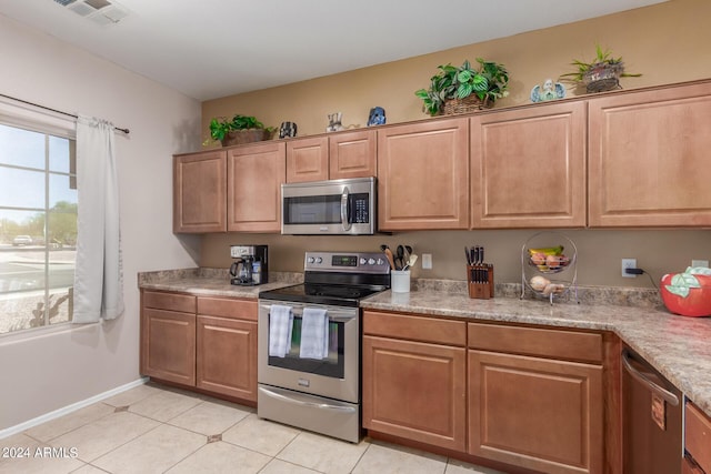 kitchen with light tile patterned floors and appliances with stainless steel finishes