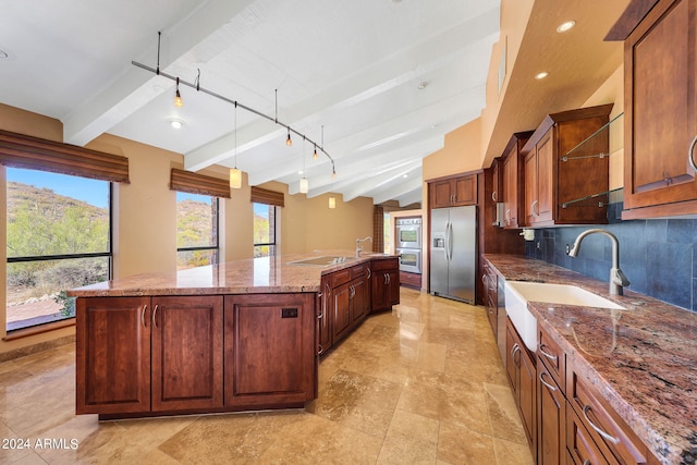 kitchen with sink, vaulted ceiling with beams, decorative backsplash, an island with sink, and stainless steel appliances