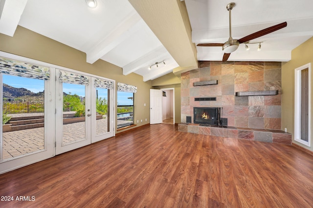 unfurnished living room with a fireplace, hardwood / wood-style floors, lofted ceiling with beams, and ceiling fan