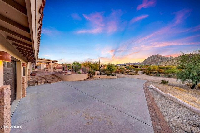 patio terrace at dusk featuring a mountain view