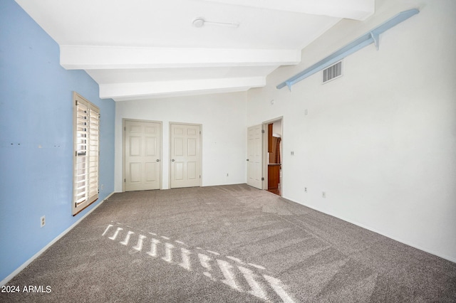 unfurnished bedroom with carpet and vaulted ceiling with beams