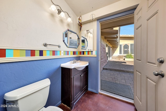 bathroom with vanity, lofted ceiling, and toilet