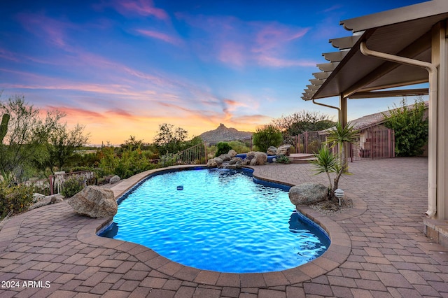 pool at dusk featuring a patio area