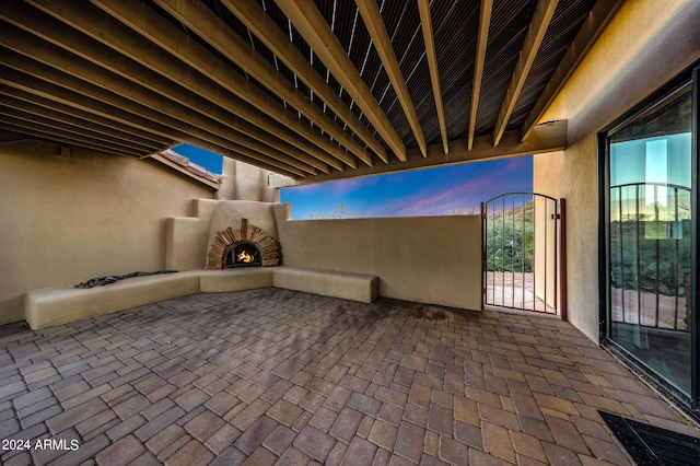 patio terrace at dusk with an outdoor brick fireplace