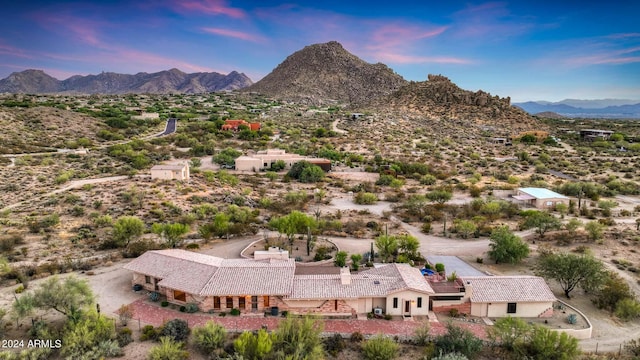 aerial view at dusk featuring a mountain view