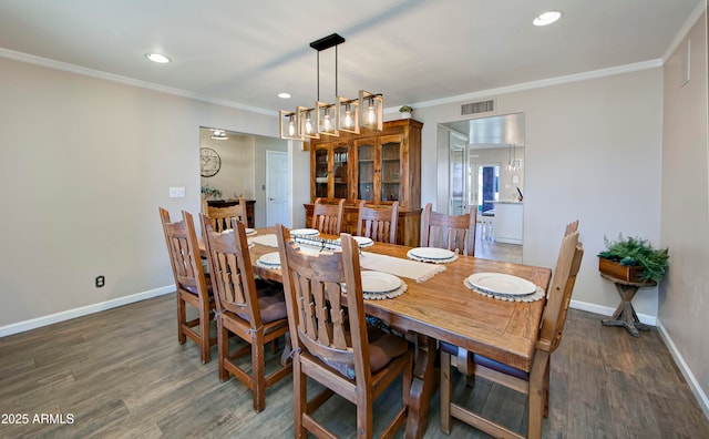 dining room with crown molding and dark hardwood / wood-style floors