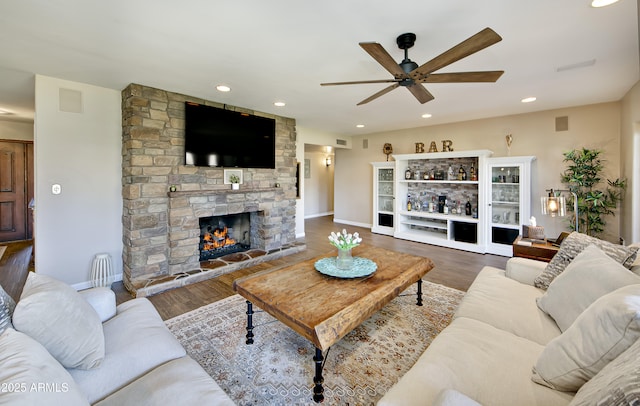 living room featuring hardwood / wood-style flooring, a fireplace, and ceiling fan