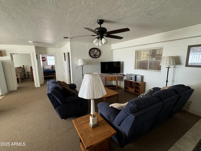 carpeted living room featuring ceiling fan and a textured ceiling