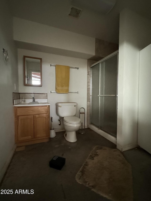 bathroom with vanity, a shower with door, and toilet