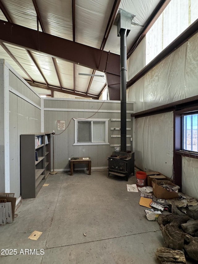 miscellaneous room featuring a wood stove and concrete floors