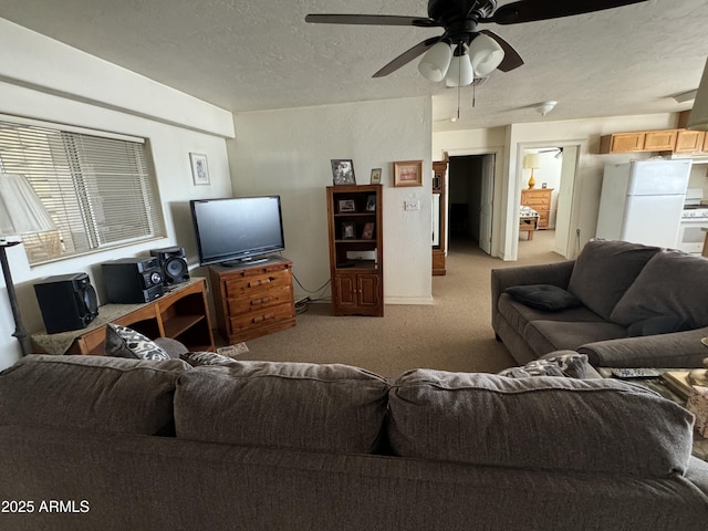 living room featuring ceiling fan, light carpet, and a textured ceiling