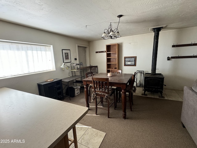 carpeted dining space with a textured ceiling and a wood stove