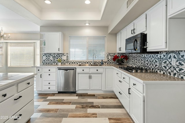 kitchen with white cabinets, backsplash, appliances with stainless steel finishes, and sink