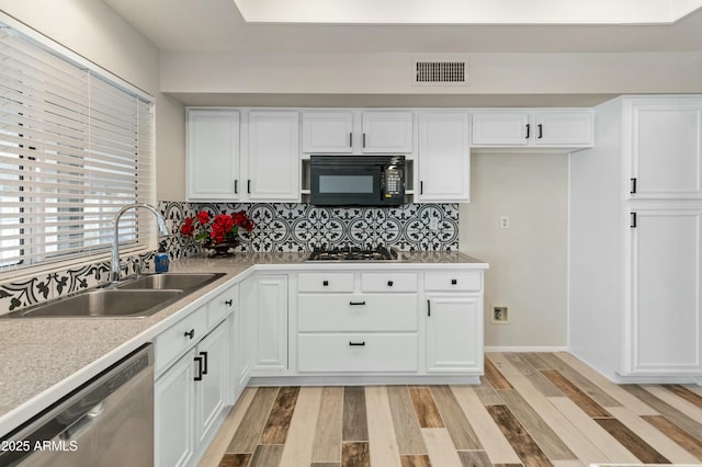 kitchen with white cabinets, dishwasher, sink, light wood-type flooring, and gas stovetop