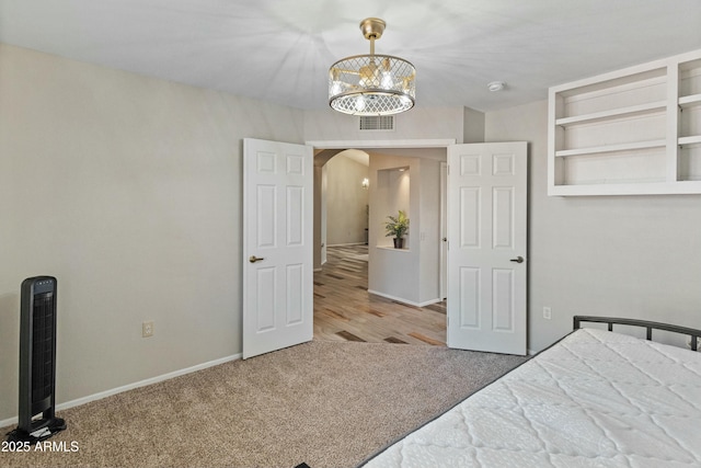 unfurnished bedroom featuring a notable chandelier and carpet flooring