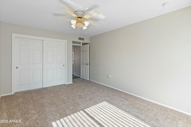 unfurnished bedroom with a closet, light colored carpet, and ceiling fan