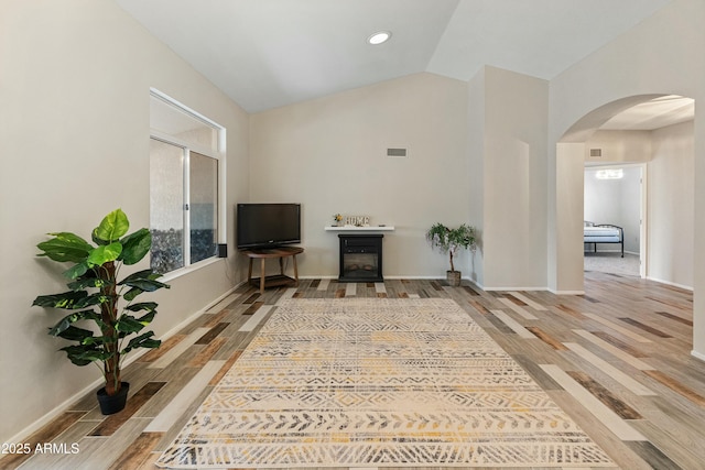 living room with wood-type flooring and vaulted ceiling