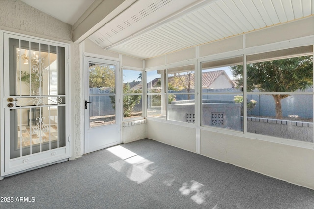 unfurnished sunroom featuring vaulted ceiling with beams