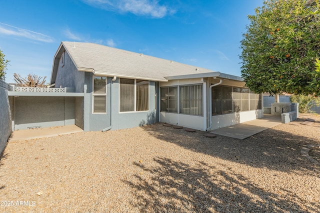 back of property with a sunroom and a patio