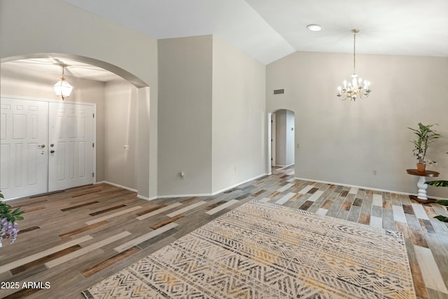 foyer with vaulted ceiling, a chandelier, and hardwood / wood-style flooring