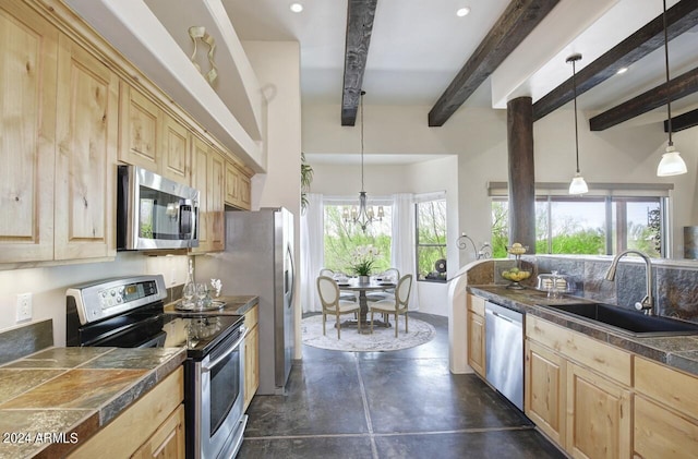 kitchen featuring sink, decorative light fixtures, a wealth of natural light, and stainless steel appliances