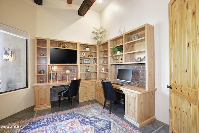 office area with beam ceiling, built in desk, and a towering ceiling