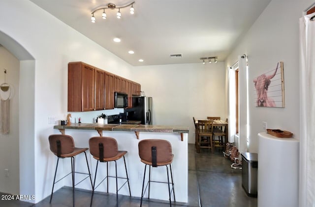 kitchen featuring a breakfast bar, kitchen peninsula, and stainless steel refrigerator with ice dispenser