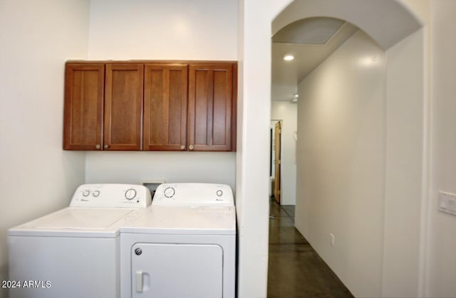 clothes washing area featuring washing machine and dryer and cabinets