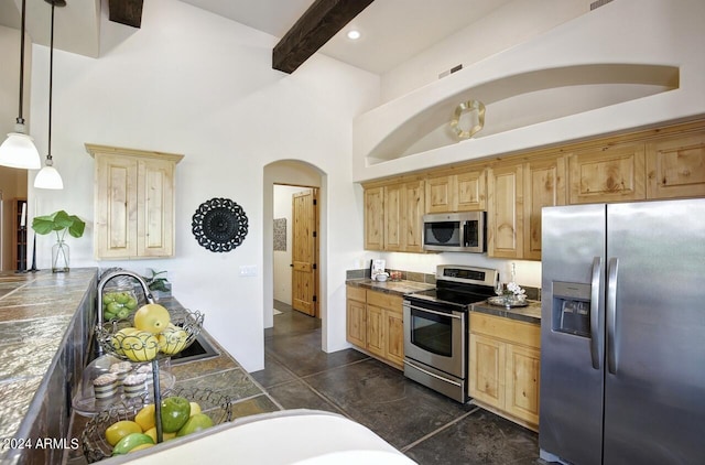 kitchen featuring pendant lighting, sink, a high ceiling, stainless steel appliances, and beam ceiling