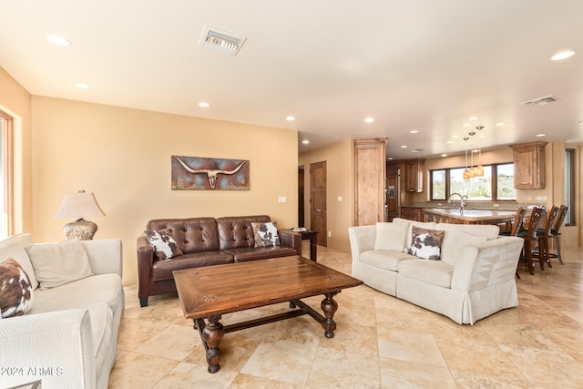 living room featuring light tile flooring and sink