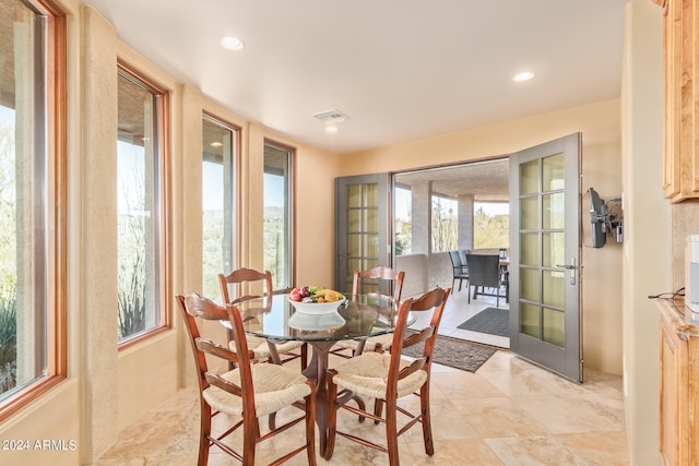 dining space featuring light tile floors and french doors