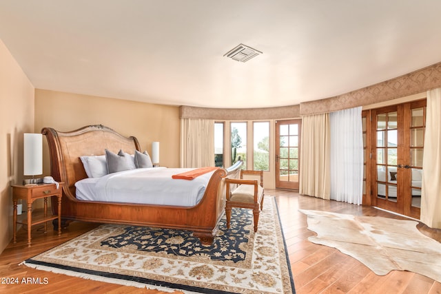 bedroom featuring french doors and light hardwood / wood-style flooring