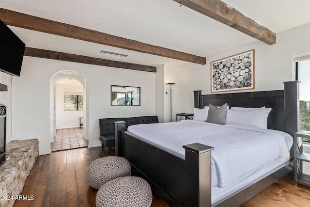 bedroom with beam ceiling and dark wood-type flooring